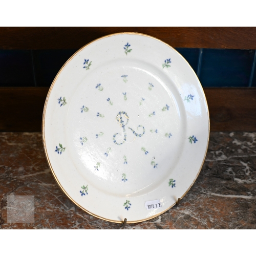 452 - An 18th century French Lille factory plate (ca 1790), painted with green and blue floral sprigs cent... 
