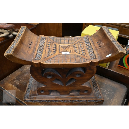 528 - An African carved wood stool with geometric patterned decoration, 39 x 53 cm, to/w a painted fibre p... 