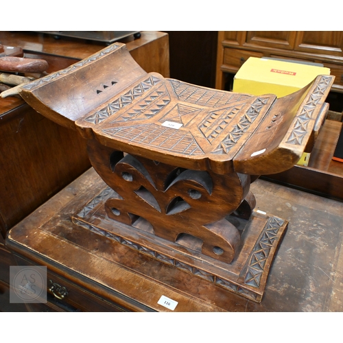 528 - An African carved wood stool with geometric patterned decoration, 39 x 53 cm, to/w a painted fibre p... 