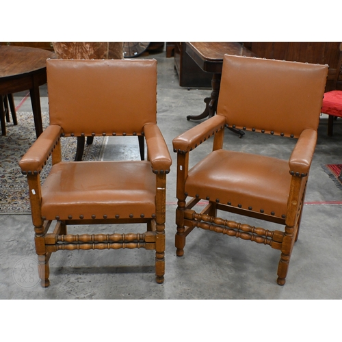 394 - A pair of traditional oak framed open arm chairs with studded tan faux leather upholstery (2)