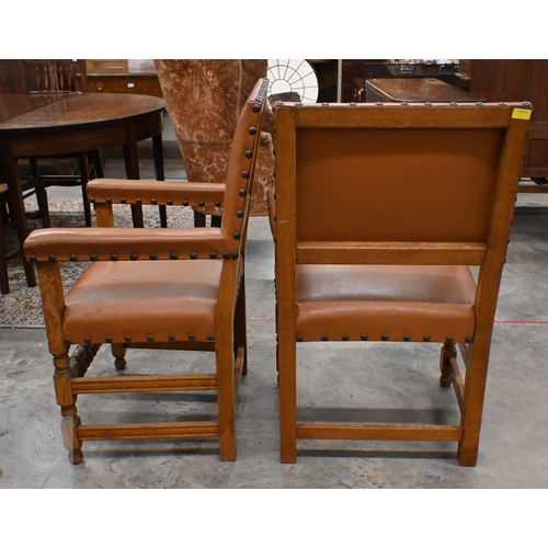 394 - A pair of traditional oak framed open arm chairs with studded tan faux leather upholstery (2)