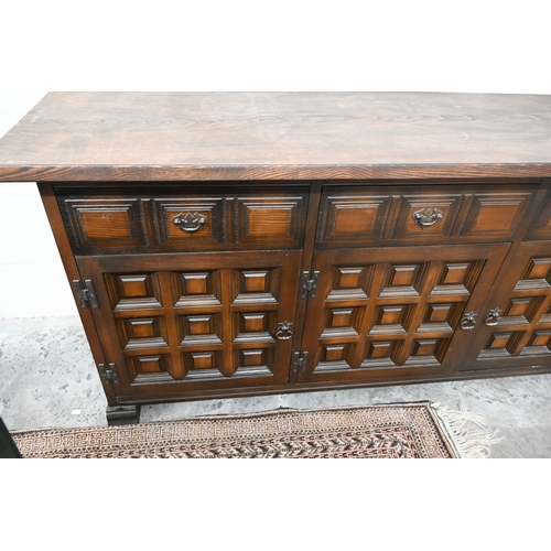 395 - A modern oak sideboard with three drawers and panelled cupboards in the antique manner
