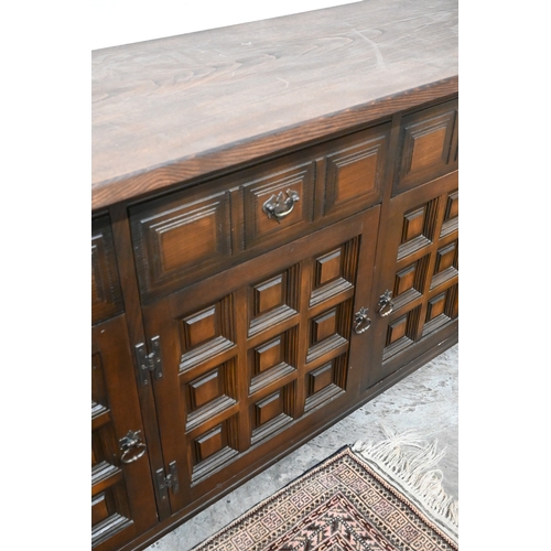 395 - A modern oak sideboard with three drawers and panelled cupboards in the antique manner
