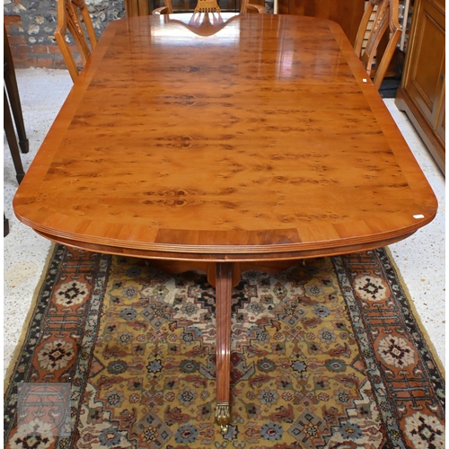 61 - # A Wade cross-banded yew veneer twin pedestal extending dining table, with two extra leaves, raised... 