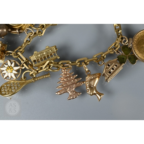 125 - An 18ct yellow gold rectangular linked curb bracelet with fifteen various charms attached including ... 