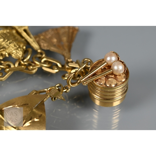 125 - An 18ct yellow gold rectangular linked curb bracelet with fifteen various charms attached including ... 