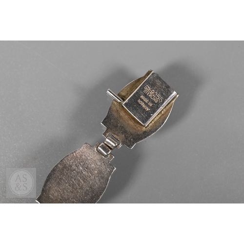 126 - A Norwegian enamel and white metal bracelet formed of eight enamelled plaques featuring Nordic scene... 