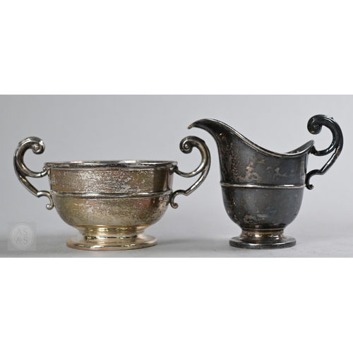 27 - An Edwardian silver three piece bachelor tea service of Empire form with composite handle and finial... 