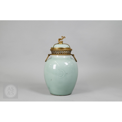 311 - An 18th century Chinese celadon jar and cover, Yueyaer guan (月牙耳罐) with gilt metal mounts, the taper... 