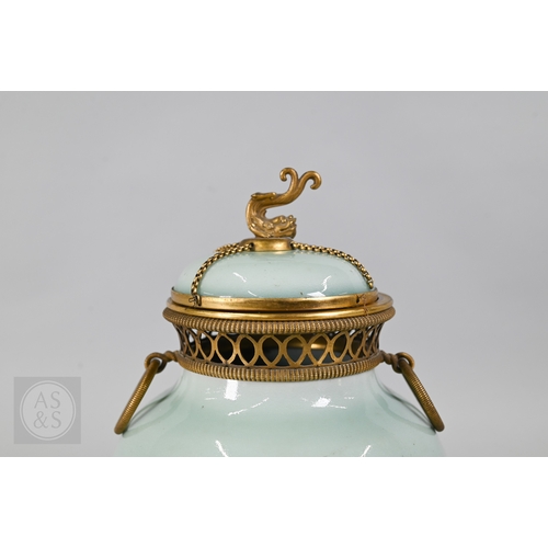311 - An 18th century Chinese celadon jar and cover, Yueyaer guan (月牙耳罐) with gilt metal mounts, the taper... 
