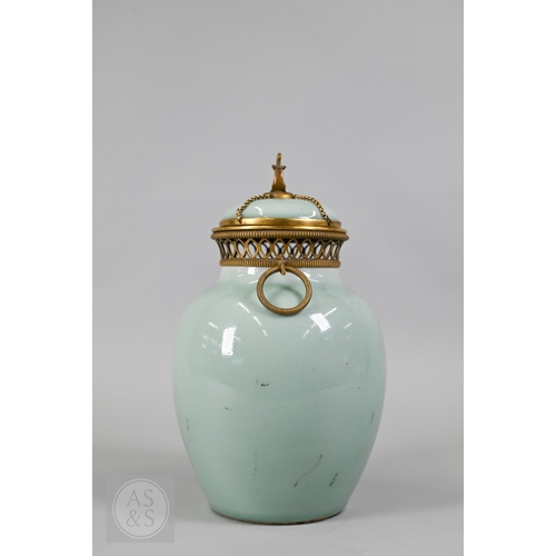 311 - An 18th century Chinese celadon jar and cover, Yueyaer guan (月牙耳罐) with gilt metal mounts, the taper... 