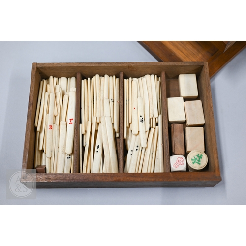 312 - An early-mid 20th century Chinese Mah Jong set, the wooden case decoratively carved with landscapes ... 