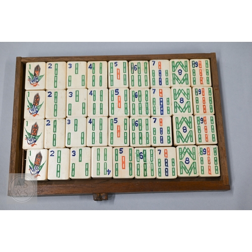 312 - An early-mid 20th century Chinese Mah Jong set, the wooden case decoratively carved with landscapes ... 