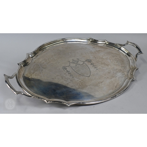 A large Edwardian silver two-handled tray of shaped oval form, with moulded rim, engraved shield and 1908 presentation inscription, C S Harris & Sons Ltd, London 1906, 78oz (2428g), 65 x 40 cm
