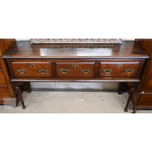 213 - A George III oak low dresser, three drawers with traditional brass handles raised on turned supports... 