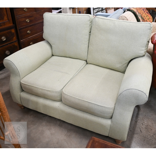A John Lewis small two-seater scroll arm sofa in 'Aquaclean Matilda' pale green fabric, 150 x 90 x 100 cm high