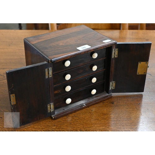 582 - A 19th century rosewood collector's cabinet with twin doors enclosing four drawers with bone handles... 