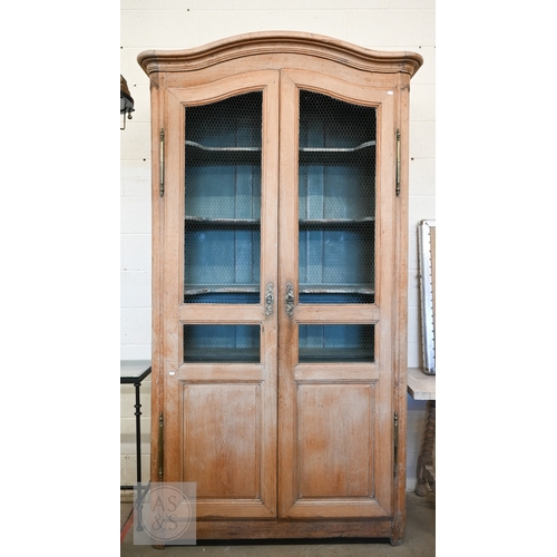 A large provincial French limed oak armoire/pantry, full length wire-mesh and panelled doors, enclosing painted interior with shelves and cupboards in Louis XV manner, 130 x 60 x 250 cm high
