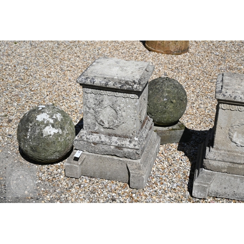 4 - A pair of old weathered cast stone ball finials raised on square cast stone plinths, 89 cm h  to/wit... 