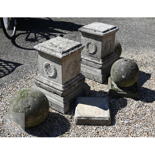 4 - A pair of old weathered cast stone ball finials raised on square cast stone plinths, 89 cm h  to/wit... 