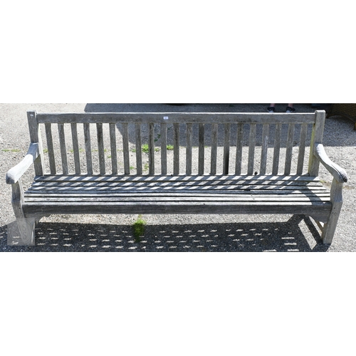 10 - A large weathered teak garden bench, 244 cm long, a/f