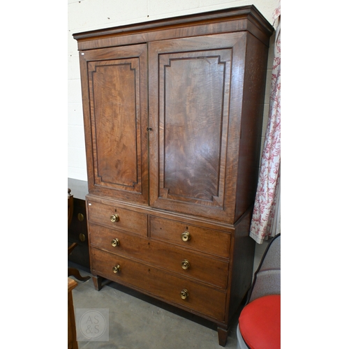 A Regency mahogany linen press with geometric panelled doors enclosing slides over two short and two long drawers with brass pulls, on tapered square feet, 125 x 56 x 206 cm high