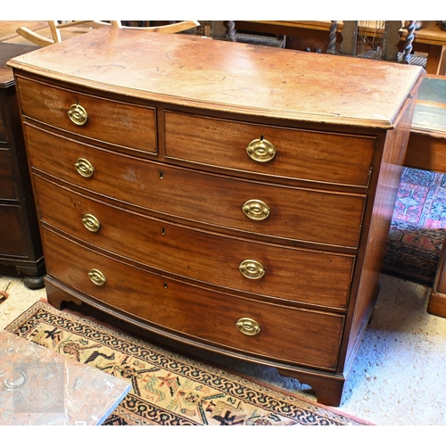 35 - A Victorian mahogany bowfront chest of two short over three long graduated drawers, with oval brass ... 