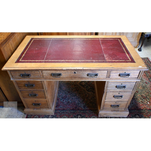 39 - An Edwardian oak twin pedestal desk, the top with inset gilt tooled burgundy leather skiver over nin... 