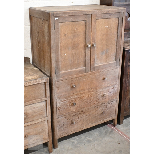 70 - Heal & Son, London - a limed oak cabinet with panelled cupboards over three drawers, ivorine pla... 