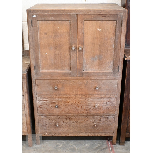70 - Heal & Son, London - a limed oak cabinet with panelled cupboards over three drawers, ivorine pla... 