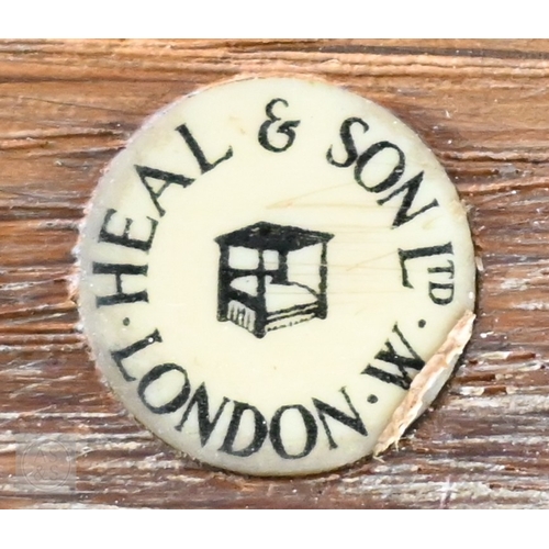 70 - Heal & Son, London - a limed oak cabinet with panelled cupboards over three drawers, ivorine pla... 