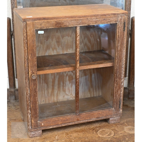 71 - Heal & Son, London - A small limed oak display cabinet with glazed door, standing on block feet,... 