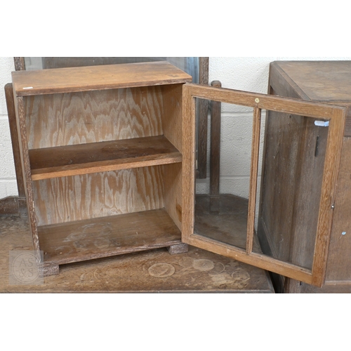 71 - Heal & Son, London - A small limed oak display cabinet with glazed door, standing on block feet,... 