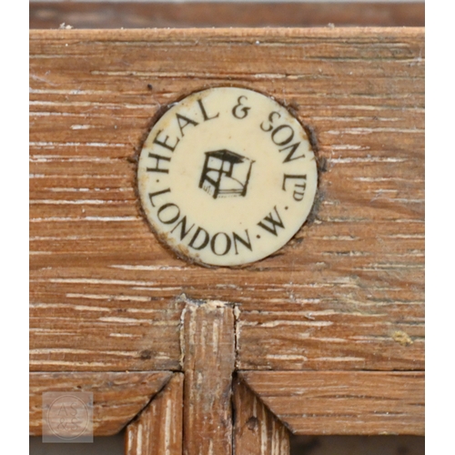 71 - Heal & Son, London - A small limed oak display cabinet with glazed door, standing on block feet,... 
