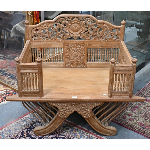 51 - An Asian teak open armchair in the form of a howdah, carved with galleried sides and spindles, 107 c... 