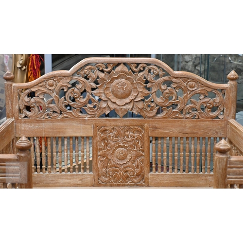51 - An Asian teak open armchair in the form of a howdah, carved with galleried sides and spindles, 107 c... 