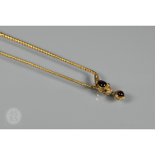 205 - An antique snake/serpent necklace, the snake head mounted with cabochon garnets and holding a heart-... 