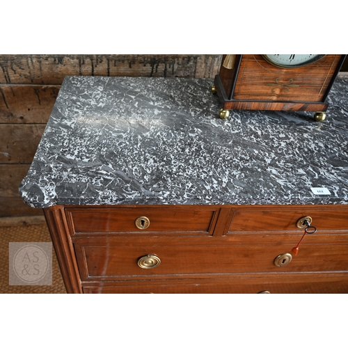 602 - A French Empire brass mounted three drawer marble top commode, 19th century, raised on turned fluted... 