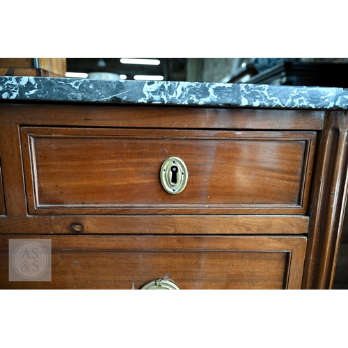 602 - A French Empire brass mounted three drawer marble top commode, 19th century, raised on turned fluted... 