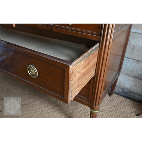 602 - A French Empire brass mounted three drawer marble top commode, 19th century, raised on turned fluted... 