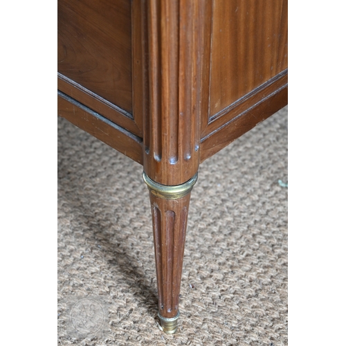 602 - A French Empire brass mounted three drawer marble top commode, 19th century, raised on turned fluted... 