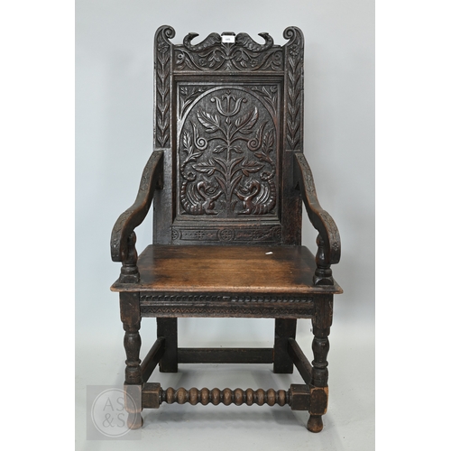 58 - An 19th century and later oak Wainscott armchair, the fielded back panel with twin dragons and folia... 