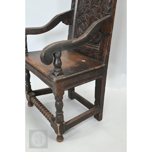 58 - An 19th century and later oak Wainscott armchair, the fielded back panel with twin dragons and folia... 