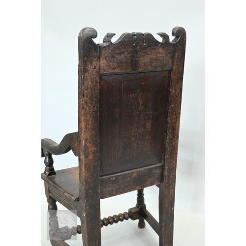 58 - An 19th century and later oak Wainscott armchair, the fielded back panel with twin dragons and folia... 