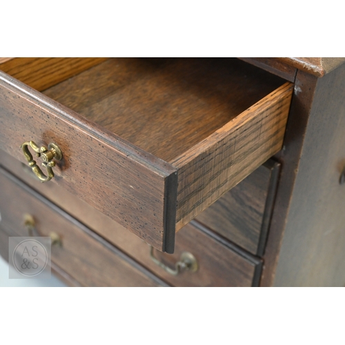 59 - A miniature Georgian style mahogany chest of two short over three long graduated drawers, with brass... 