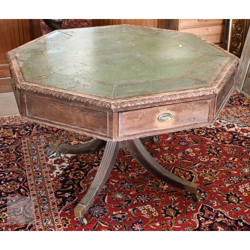 A Victorian carved oak octagonal library drum table with gilt tooled green leather top, turned column with splayed legs terminating with brass caps and casters, 110 cm diam x 74 cm high