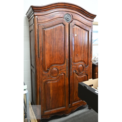 111 - A French Louis XV style provincial armoire with twin panelled doors enclosing a hanging rail and a s... 