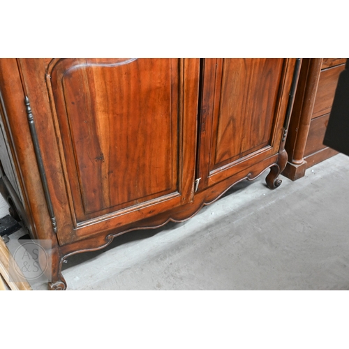 111 - A French Louis XV style provincial armoire with twin panelled doors enclosing a hanging rail and a s... 