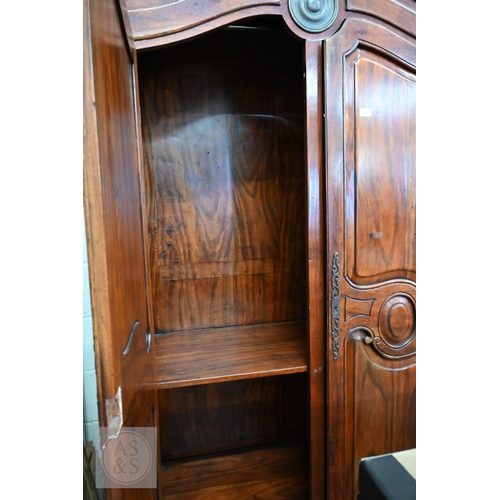 111 - A French Louis XV style provincial armoire with twin panelled doors enclosing a hanging rail and a s... 