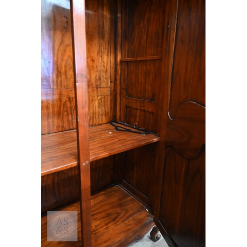 111 - A French Louis XV style provincial armoire with twin panelled doors enclosing a hanging rail and a s... 